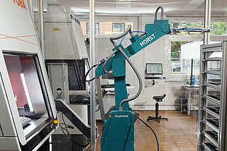 Der Industrieroboter „Horst“ der Firma fruitcore robotics be- und entlädt die FOBA M3000-Lasermarkierstation beim Lasermarkierdienstleister add’n solutions in Tuttlingen. (Bildrechte: fruitcore robotics)